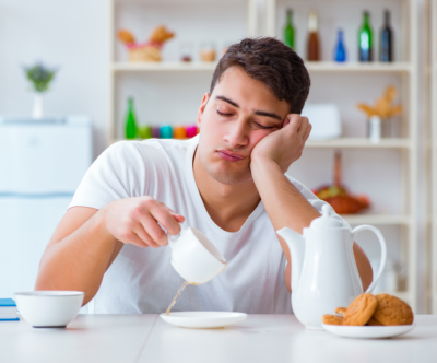 Photo of exhausted man falling asleep sitting up because sleep-wake cycles are out of sync.