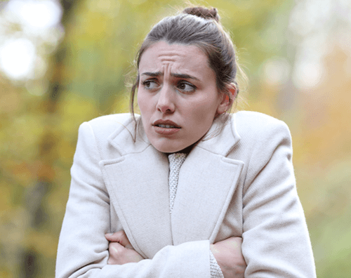 Photo of woman freezing in cold weather, which is an aggravating factor for patients with fibromyalgia.